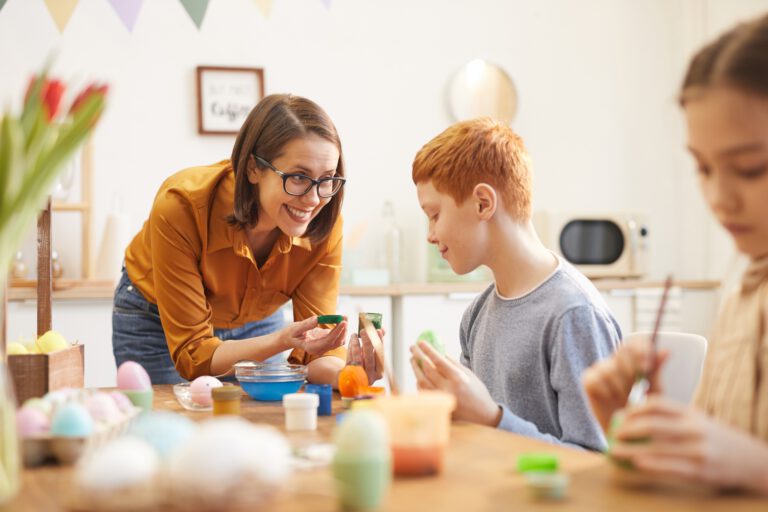 Mother helping children to paint