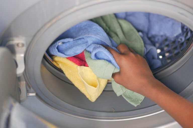 putting towel and cloths in a washing machine.